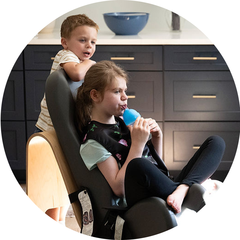 Evie drinking water in a kitchen with her brother